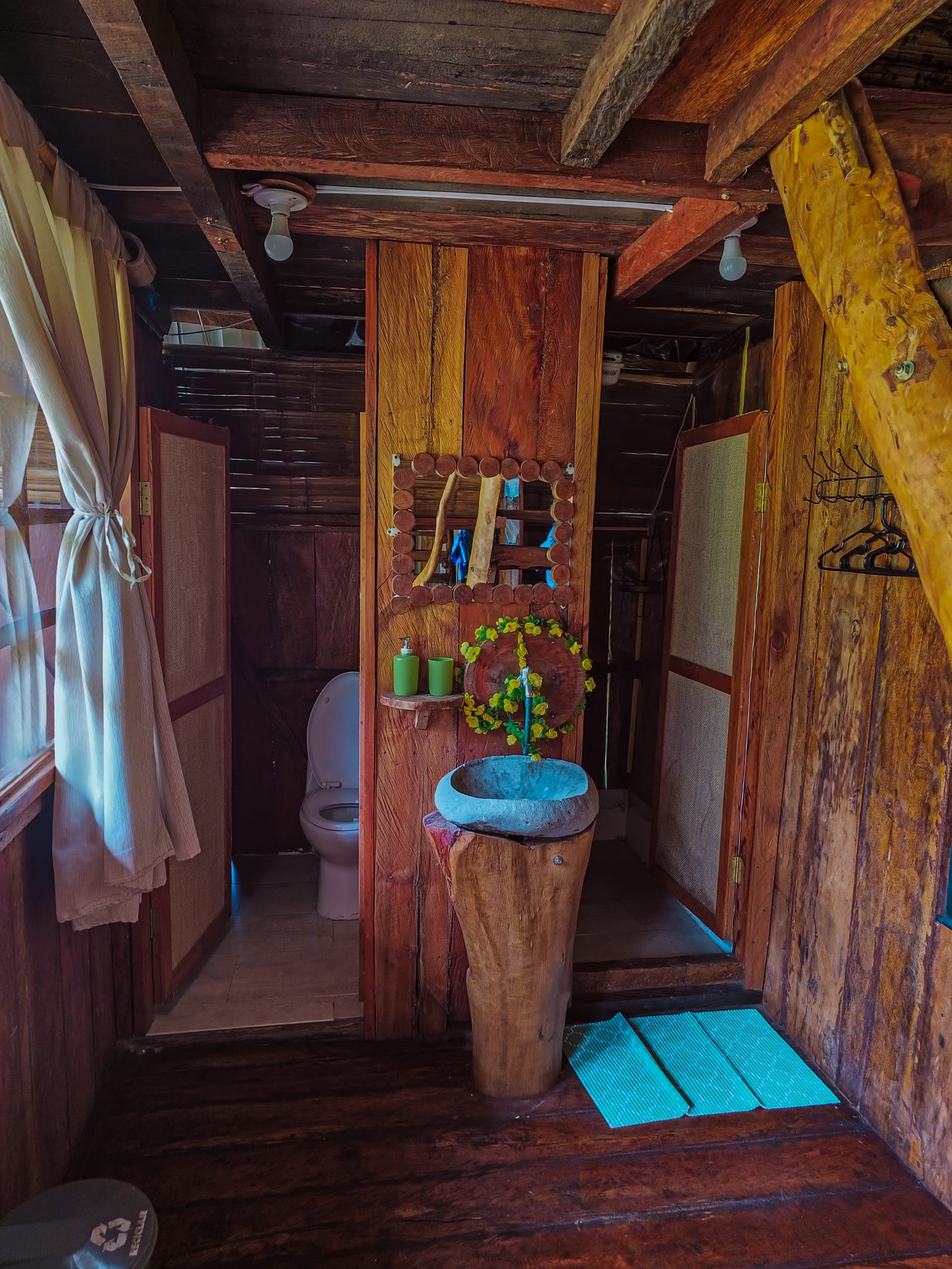 Baño rústico de madera con lavamanos de piedra